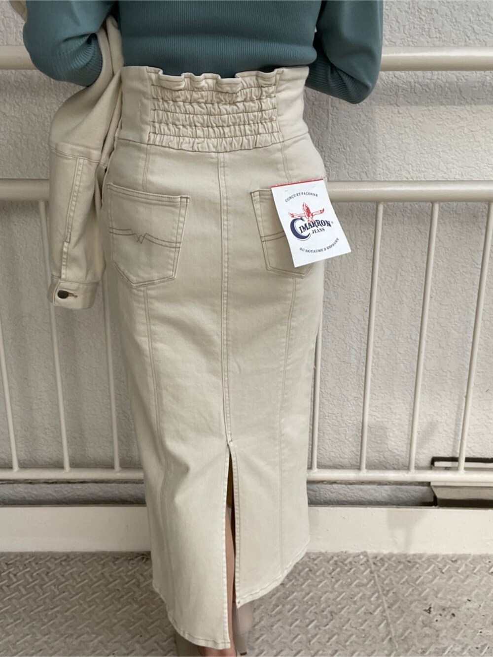 ホワイト系のブルゾン、ホワイト系のスカート、ホワイト系のパンプスを着用したレディースの冬コーディネートの10枚目の写真