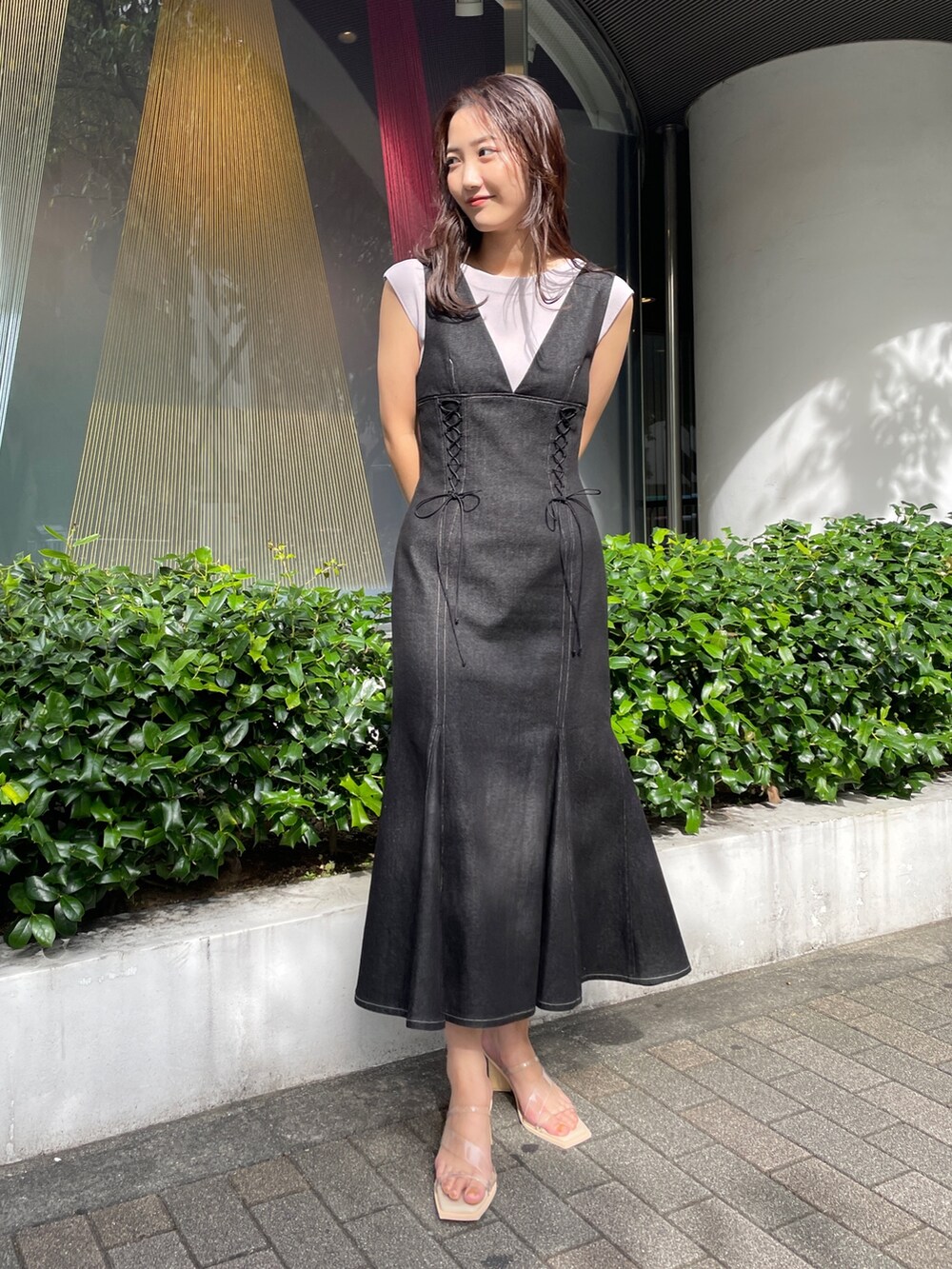 ブラック系のデニムジャケット、ブラック系のワンピース、その他のサンダルを着用したレディースの冬コーディネートの5枚目の写真