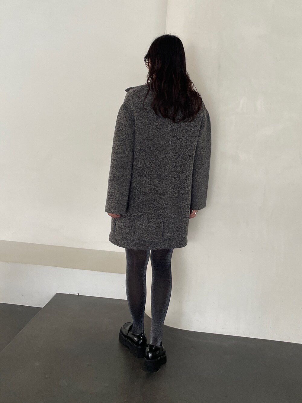 グレー系のワンピース、ブラック系のローファー、グレー系のテーラードジャケットを着用したレディースの冬コーディネートの5枚目の写真