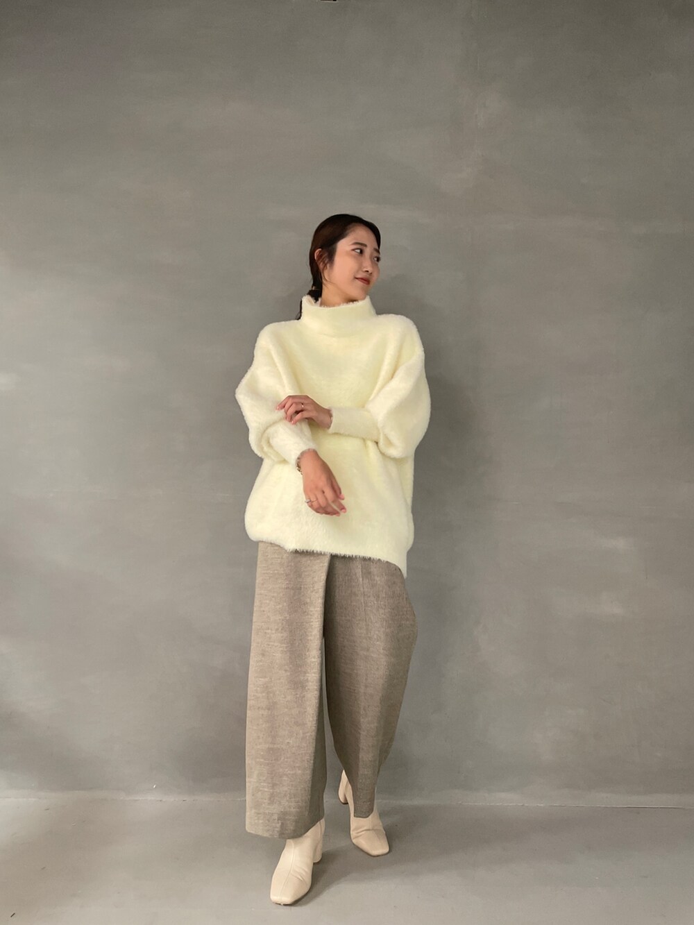 ホワイト系のニット/セーター、ベージュ系のその他パンツ、ホワイト系のブーツを着用したレディースの夏コーディネートの4枚目の写真