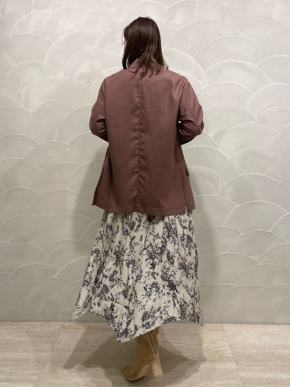 パープル系のテーラードジャケット、ベージュ系のブーツ、グレー系のワンピースを着用したレディースの春コーディネートの3枚目の写真