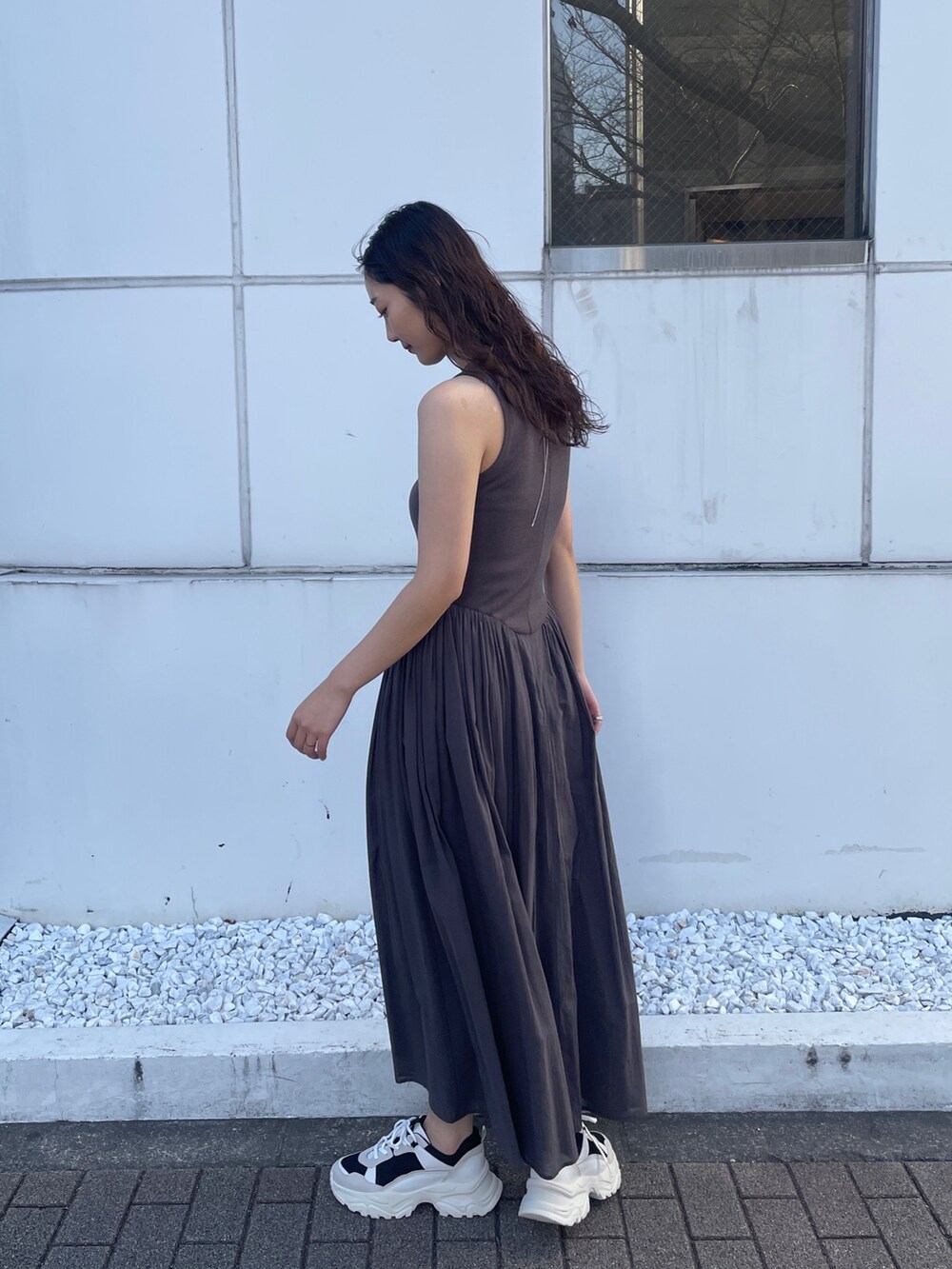 グレー系のワンピース、ブラック系のスニーカーを着用したレディースの春コーディネートの6枚目の写真