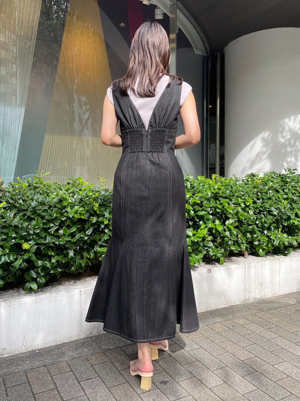 ブラック系のデニムジャケット、ブラック系のワンピース、その他のサンダルを着用したレディースの冬コーディネートの7枚目の写真