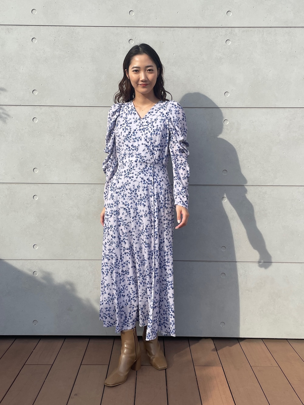 パープル系のワンピース、ベージュ系のブーツを着用したレディースの冬コーディネートの2枚目の写真