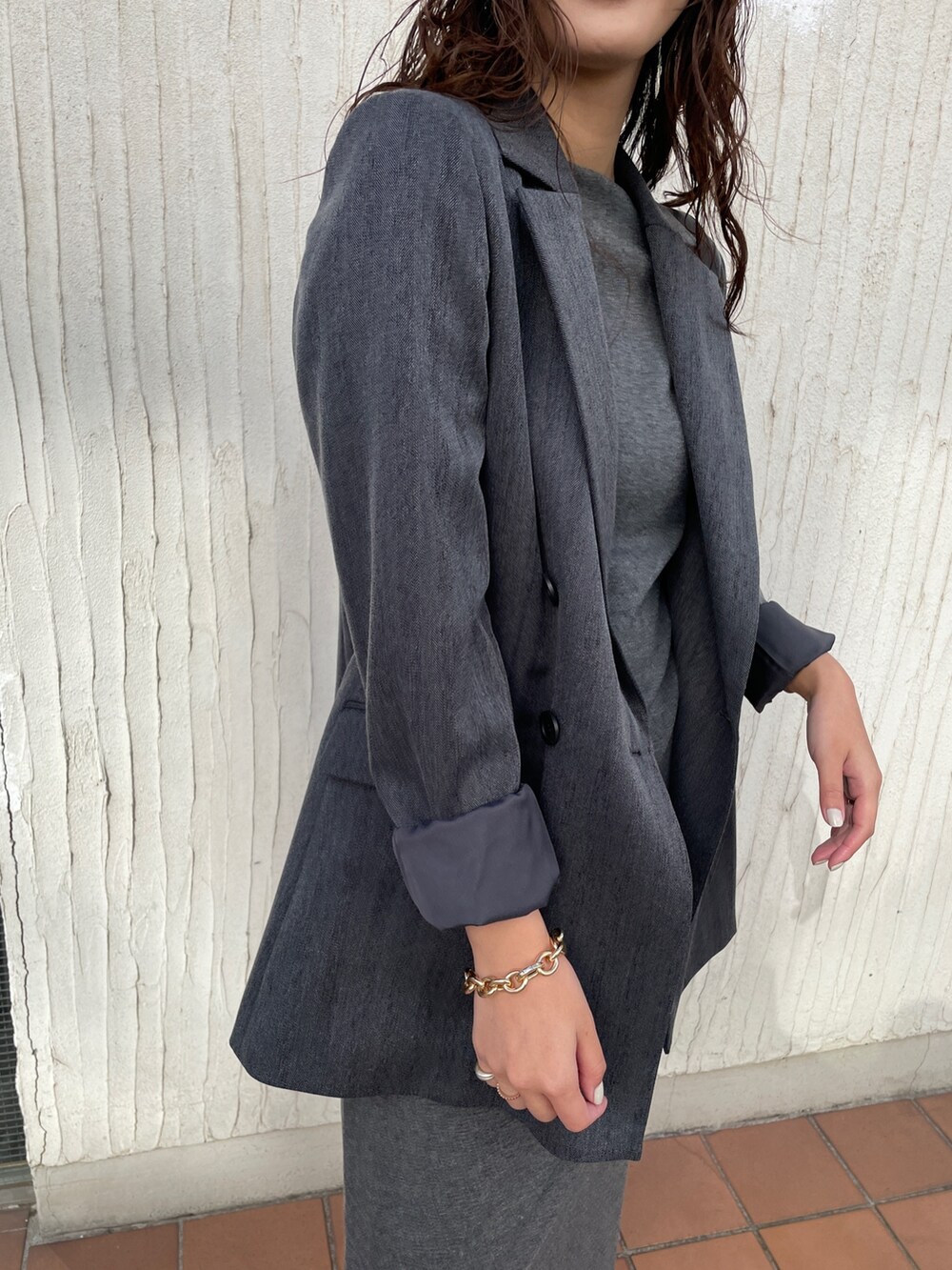 ホワイト系のスニーカー、グレー系のワンピース、グレー系のテーラードジャケットを着用したレディースの冬コーディネートの8枚目の写真