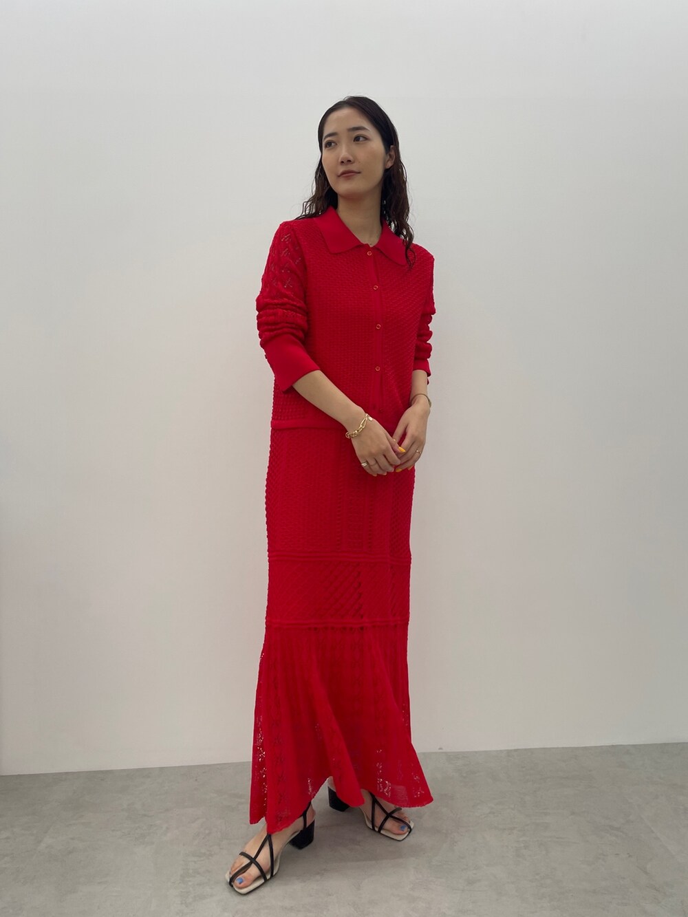 レッド系のカーディガン/ボレロ、レッド系のスカート、ブラック系のサンダルを着用したレディースの春コーディネートの3枚目の写真