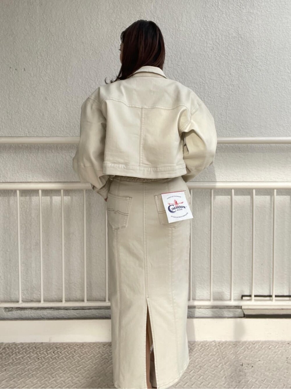 ホワイト系のブルゾン、ホワイト系のスカート、ホワイト系のパンプスを着用したレディースの冬コーディネートの8枚目の写真