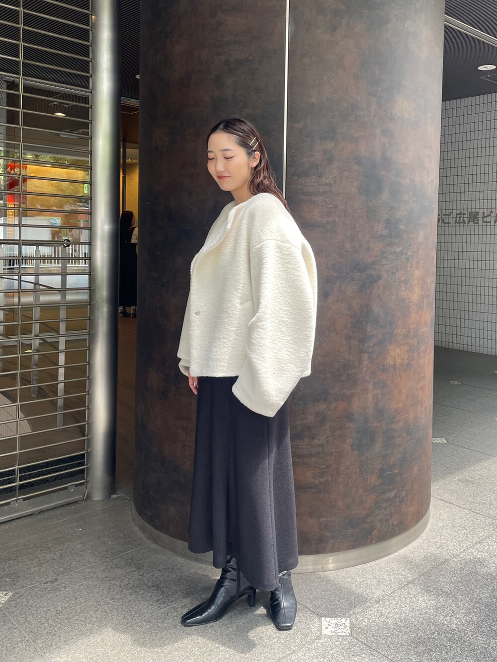 ブラック系のジャンパースカート、ピンク系のニット/セーター、ブラック系のブーツを着用したレディースの夏コーディネートの3枚目の写真