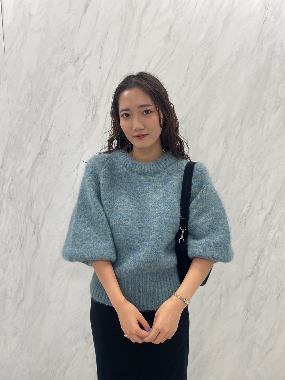 グリーン系のニット/セーター、ブラック系のブーツ、ブラック系のスカートを着用したレディースの冬コーディネートの7枚目の写真