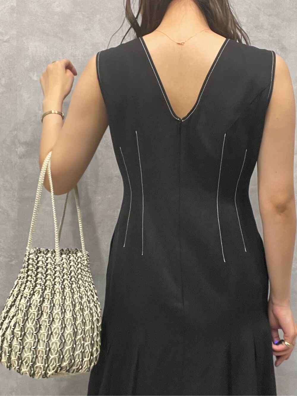 ブラウン系のサンダル、ホワイト系のハンドバッグ、ブラック系のワンピースを着用したレディースの夏コーディネートの9枚目の写真