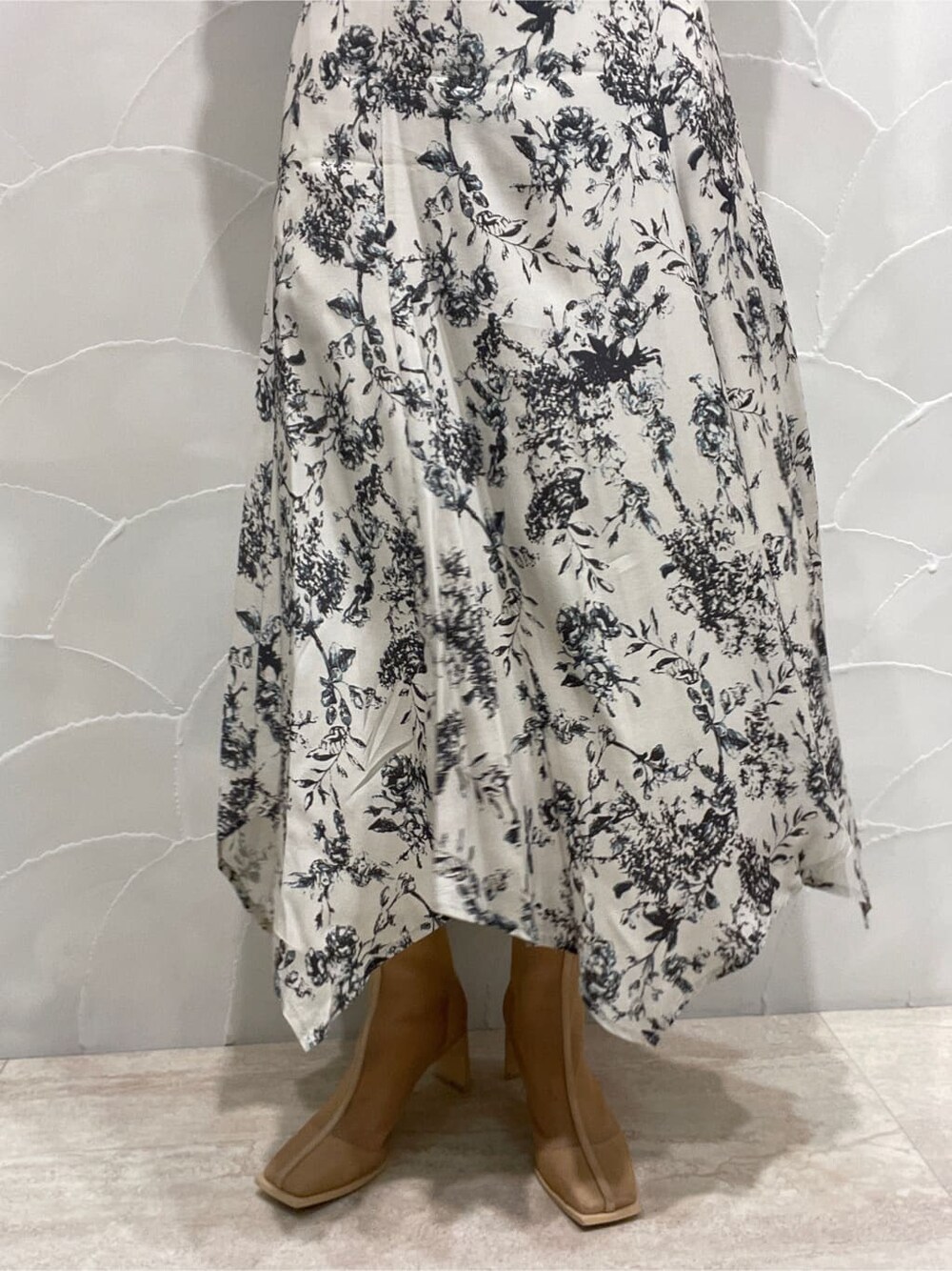 パープル系のテーラードジャケット、ベージュ系のブーツ、グレー系のワンピースを着用したレディースの春コーディネートの10枚目の写真