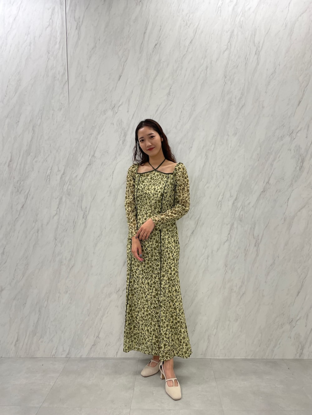 ホワイト系のパンプス、グリーン系のワンピースを着用したレディースの冬コーディネートの3枚目の写真