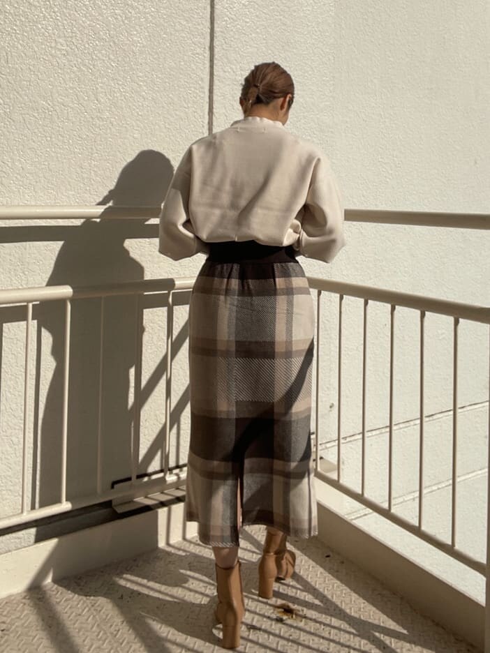 ベージュ系のその他シューズ、グレー系のスカート、ホワイト系のニット/セーターを着用したレディースの冬コーディネートの2枚目の写真