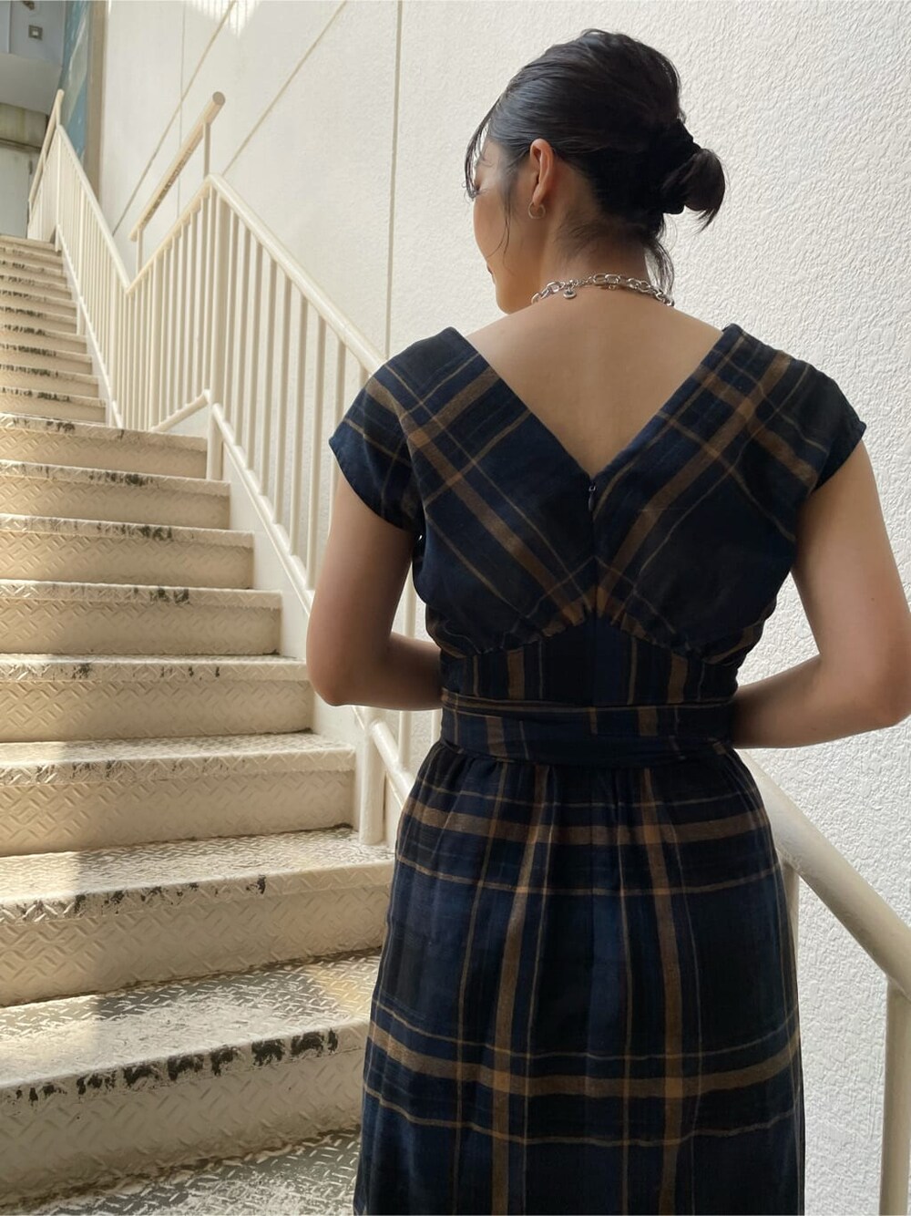 ホワイト系のスニーカー、ブルー系のワンピース、シルバー系のネックレスを着用したレディースの夏コーディネートの5枚目の写真