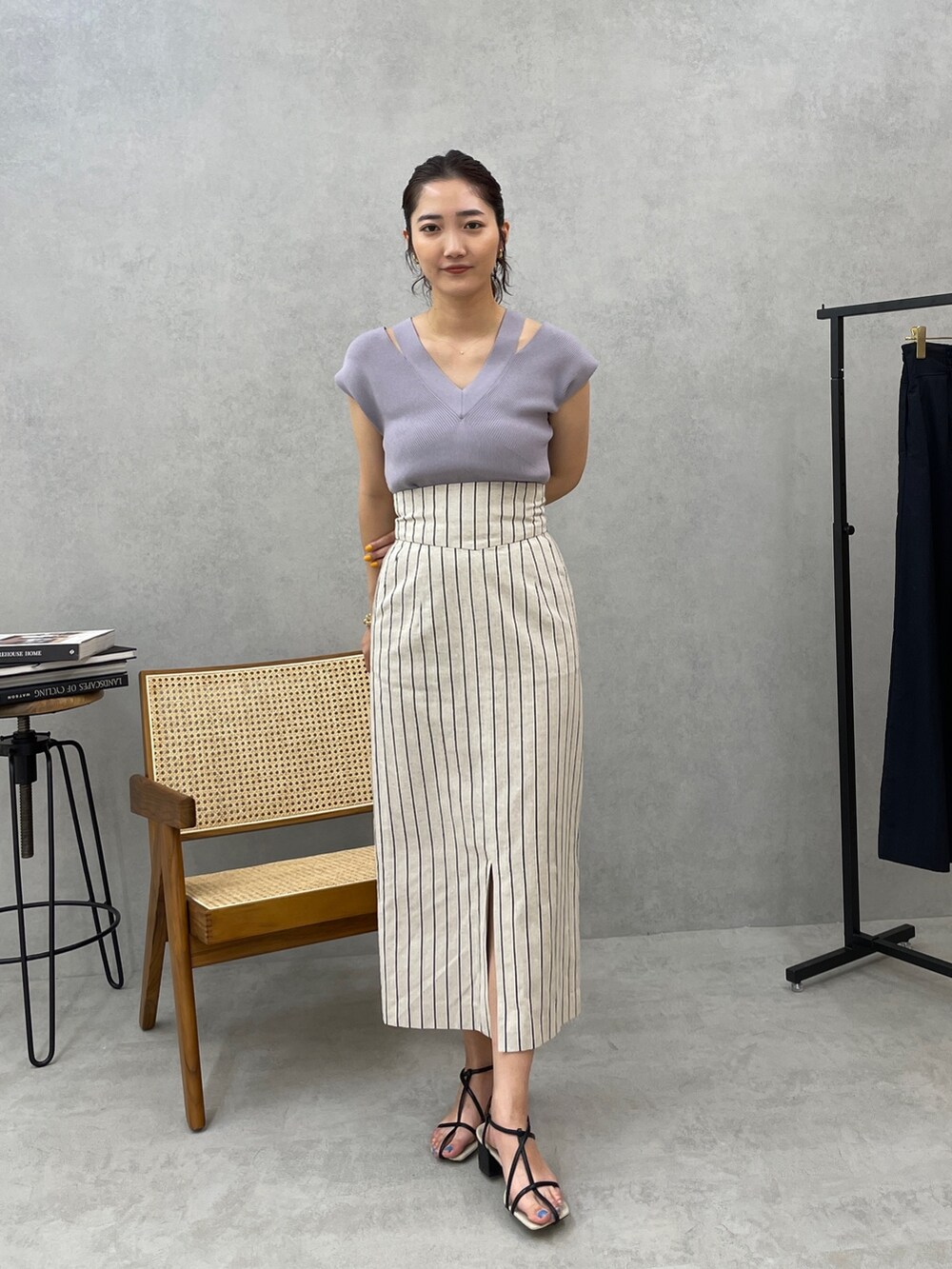 グレー系のスカート、ホワイト系のテーラードジャケット、ブルー系のニット/セーターを着用したレディースの春コーディネートの5枚目の写真