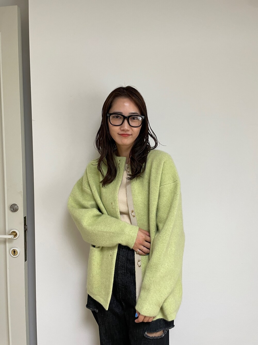 ブラック系のデニムパンツ、ブルー系のサンダル、グリーン系のカーディガン/ボレロを着用したレディースの夏コーディネートの4枚目の写真