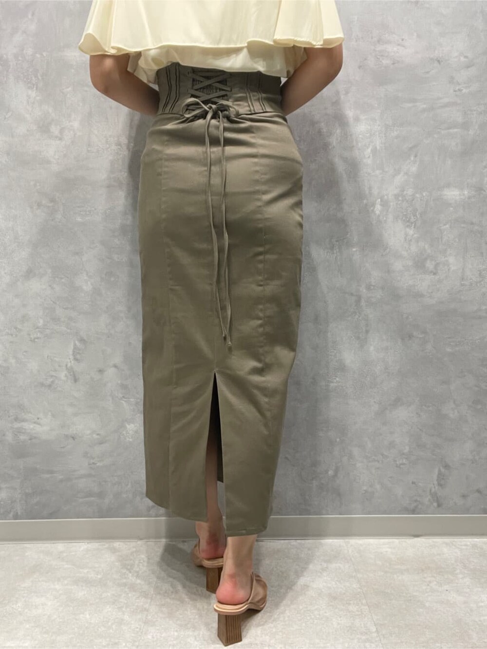 ベージュ系のスカート、ベージュ系のサンダル、ホワイト系のシャツ/ブラウスを着用したレディースの夏コーディネートの9枚目の写真