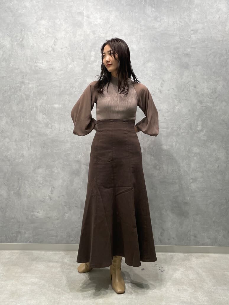 ベージュ系のブーツ、ブラウン系のスカート、ベージュ系のニット/セーターを着用したレディースの秋コーディネートの3枚目の写真