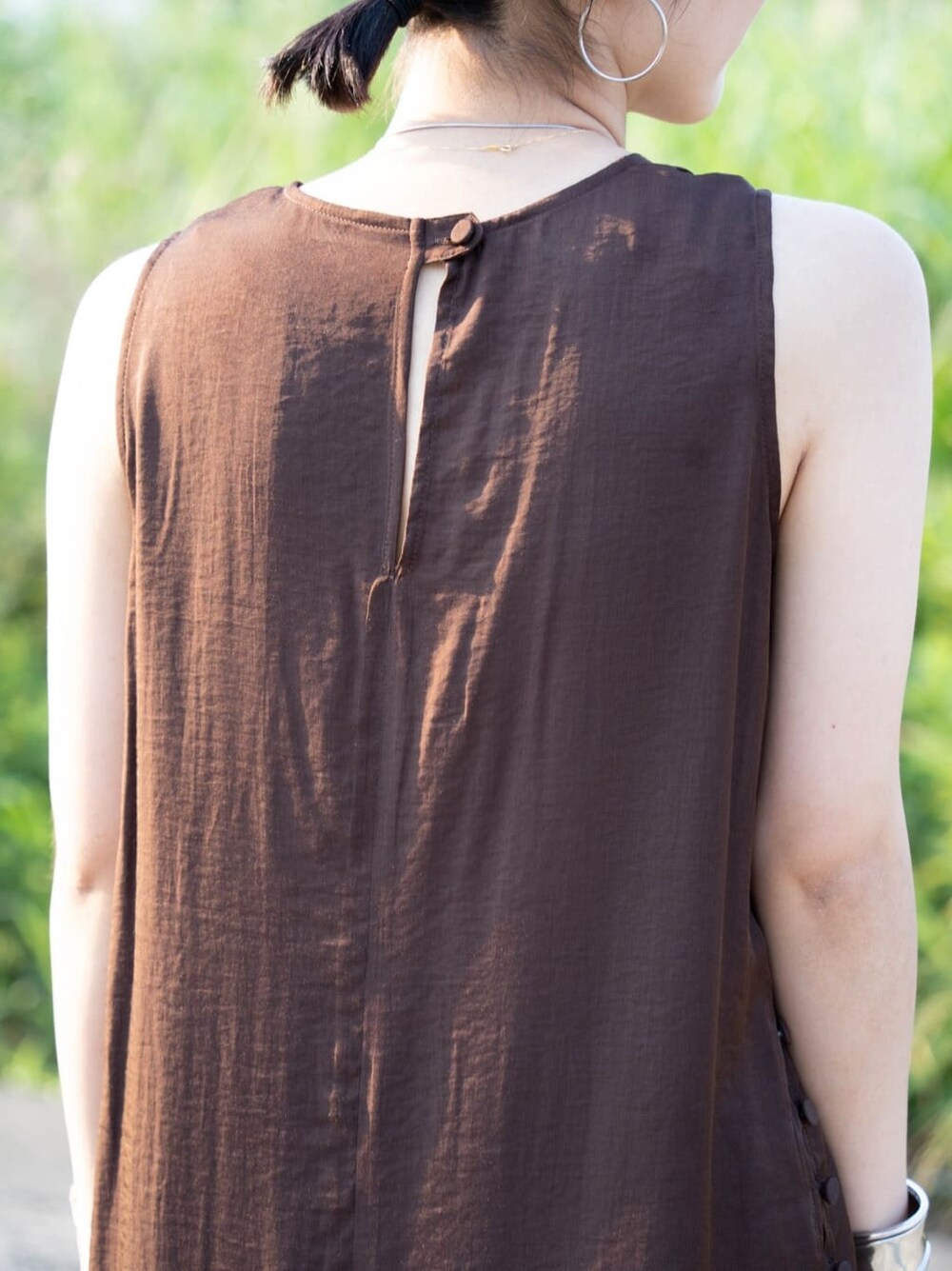 ブラウン系のワンピース、シルバー系のバングル/リストバンドを着用したレディースの夏コーディネートの8枚目の写真