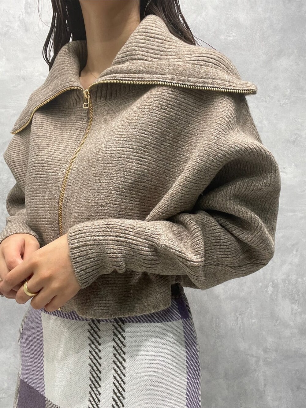 ベージュ系のブーツ、ベージュ系のカーディガン/ボレロ、パープル系のスカートを着用したレディースの秋コーディネートの7枚目の写真