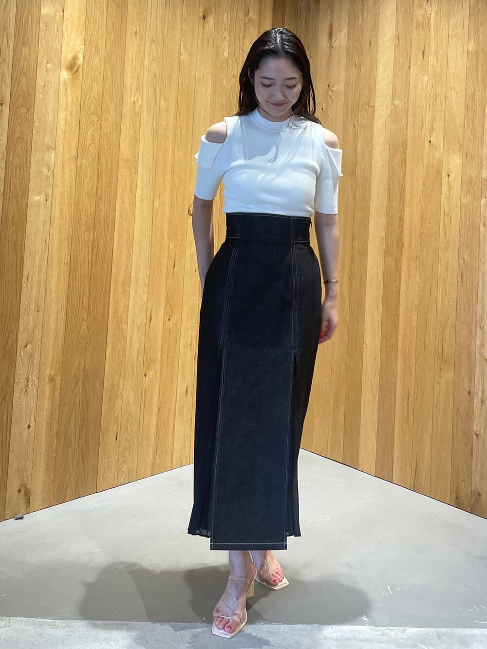 その他のサンダル、ブラック系のデニムスカート、ホワイト系のニット/セーターを着用したレディースの冬コーディネートの2枚目の写真