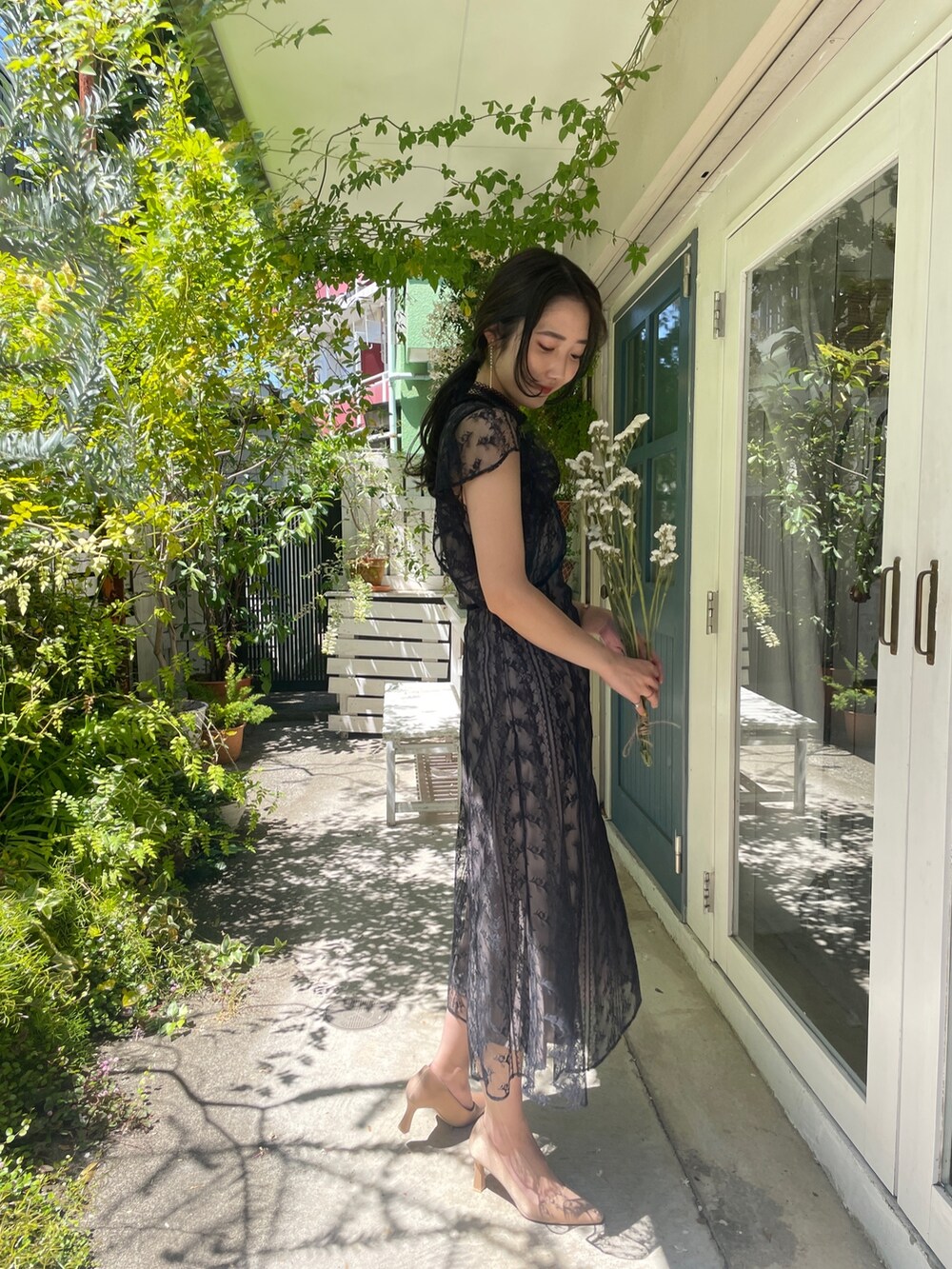 ゴールド系のパンプス、ブラック系のドレスを着用したレディースの夏コーディネートの5枚目の写真