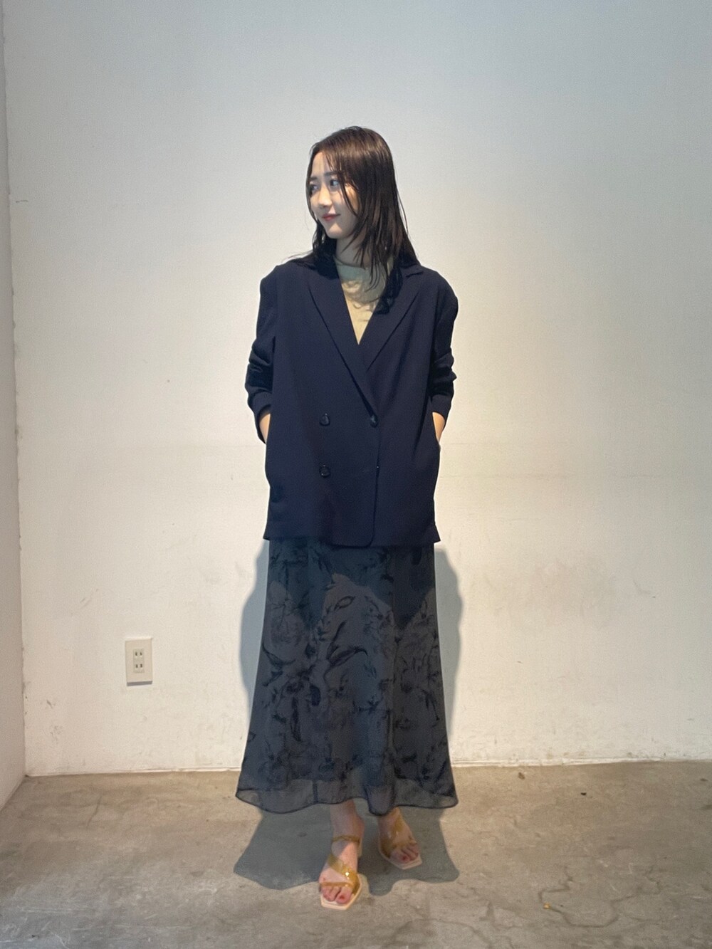 グレー系のスカート、イエロー系のサンダル、ブルー系のテーラードジャケットを着用したレディースの夏コーディネートの2枚目の写真