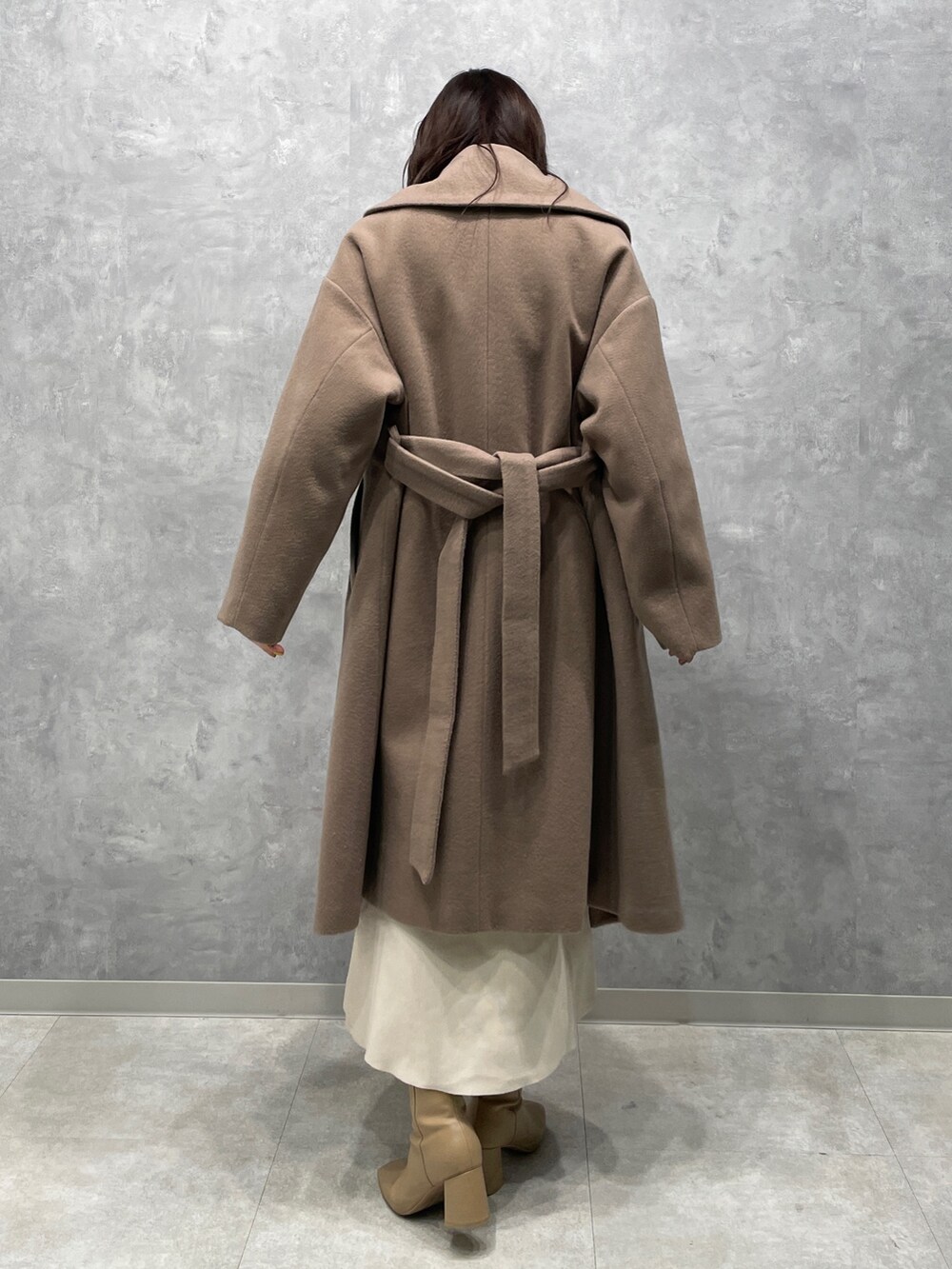 ベージュ系のブーツ、グリーン系のニット/セーター、ベージュ系のその他アウターを着用したレディースの冬コーディネートの3枚目の写真