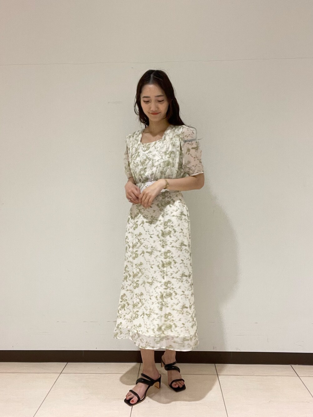 ブラック系のサンダル、ホワイト系のワンピースを着用したレディースの春コーディネートの2枚目の写真