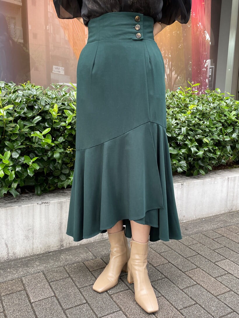 ベージュ系のトレンチコート、グリーン系のスカート、ベージュ系のトレンチコートを着用したレディースの秋コーディネートの10枚目の写真