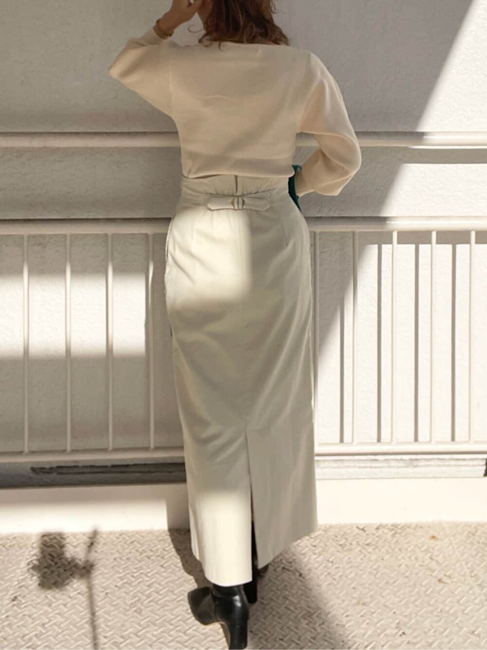 ブラック系のその他シューズ、ホワイト系のスカート、ホワイト系のニット/セーターを着用したレディースの冬コーディネートの9枚目の写真