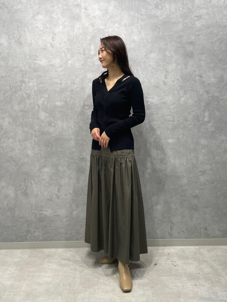 ベージュ系のスカート、ベージュ系のブーツ、ブラック系のニット/セーターを着用したレディースの秋コーディネートの4枚目の写真