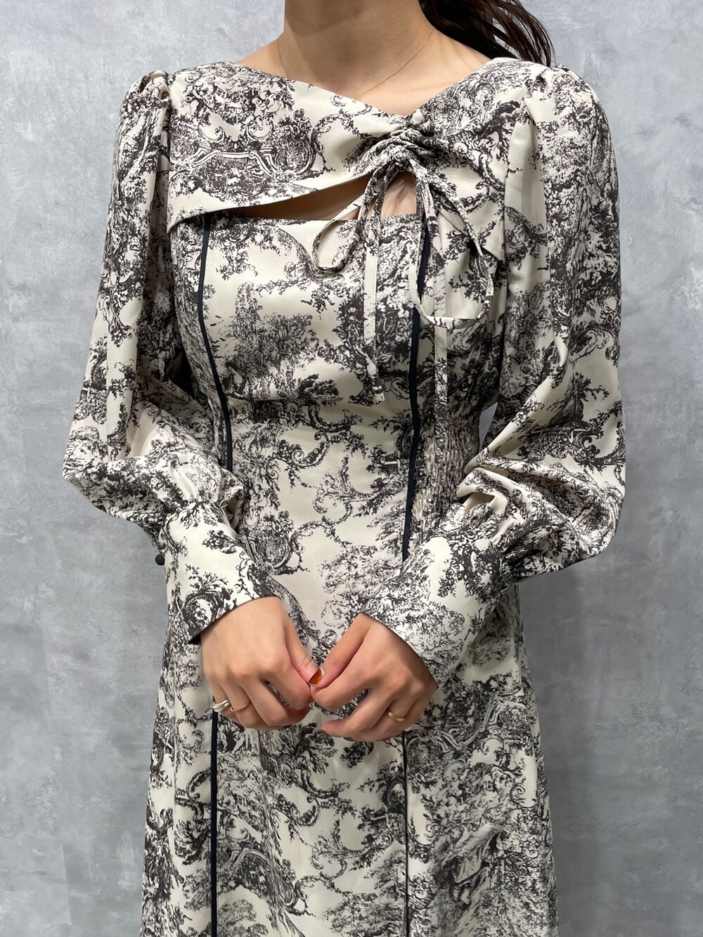 グレー系のカーディガン/ボレロ、ホワイト系のワンピース、ブラック系のブーツを着用したレディースの冬コーディネートの9枚目の写真