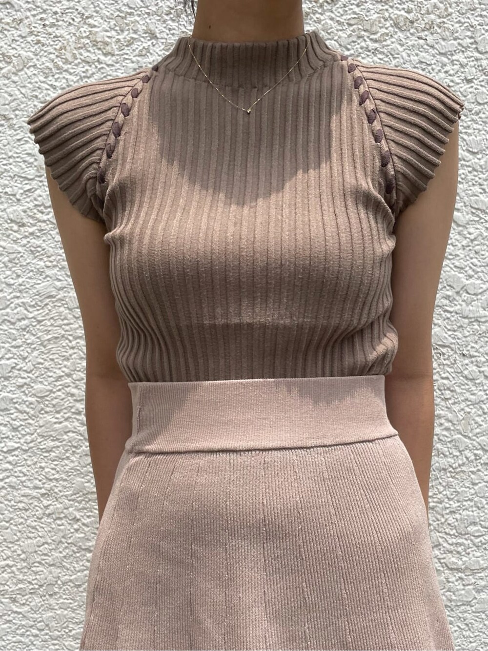 ベージュ系のスカート、ホワイト系のサンダル、ベージュ系のニット/セーターを着用したレディースの夏コーディネートの5枚目の写真