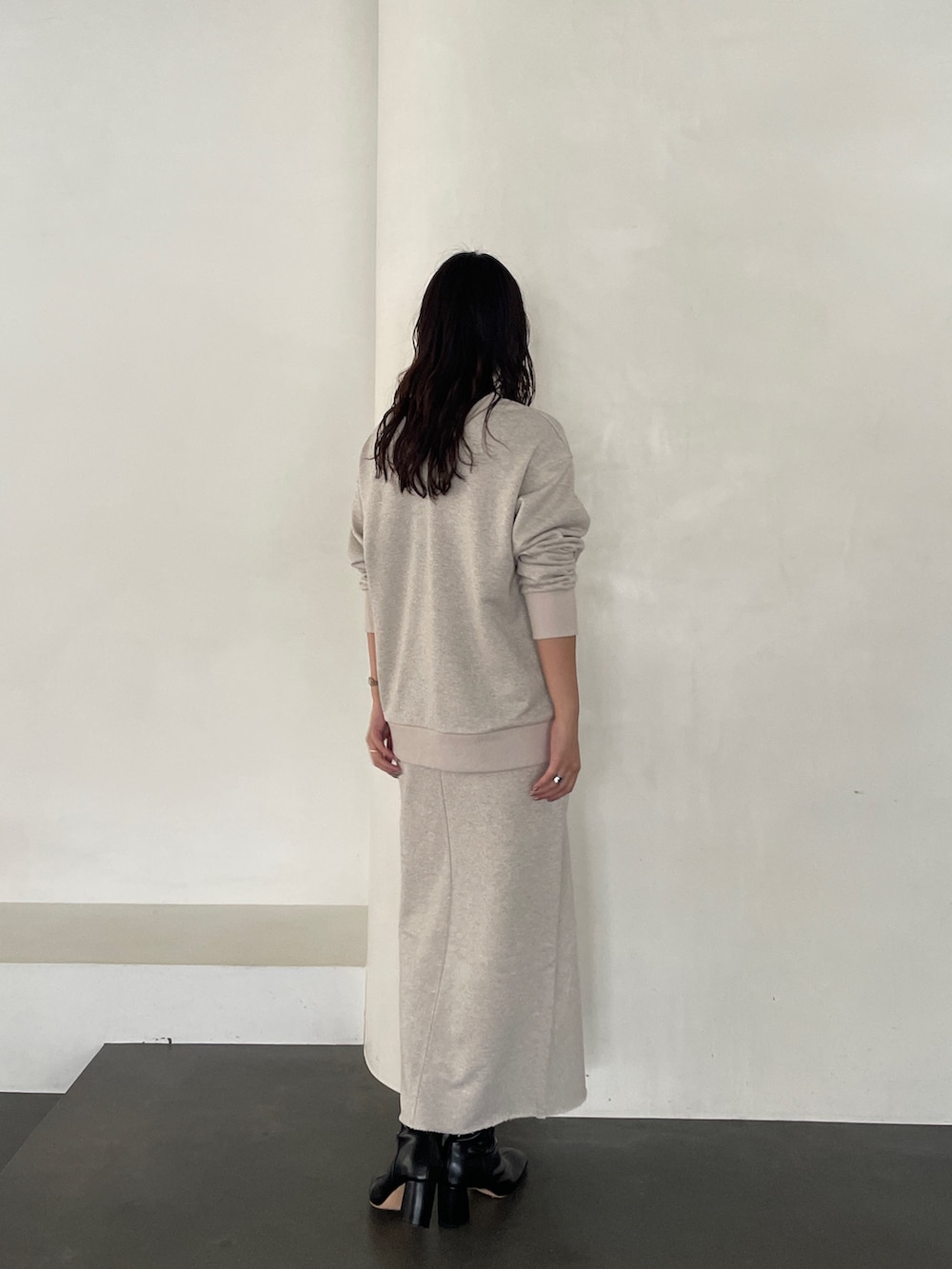 ブラック系のブーツ、ベージュ系のスカート、ベージュ系のスウェットを着用したレディースの秋コーディネートの5枚目の写真