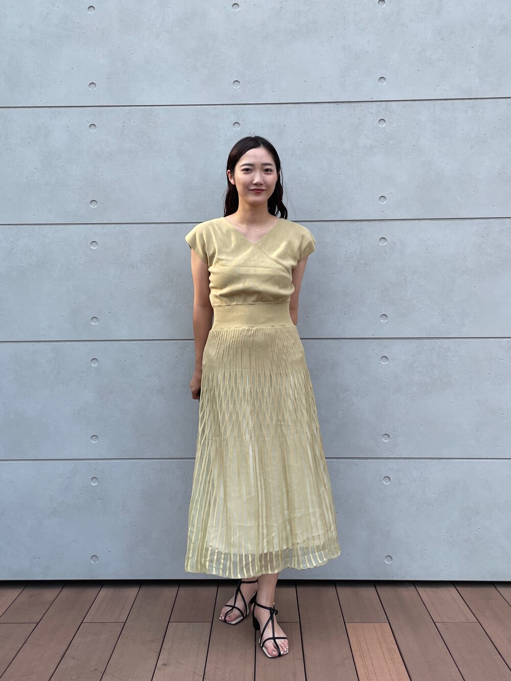 グリーン系のワンピース、ブラック系のサンダルを着用したレディースの夏コーディネートの2枚目の写真