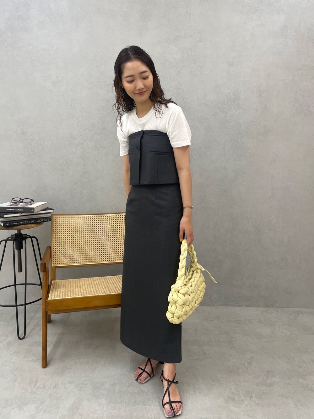 グレー系のスカート、ホワイト系のTシャツ/カットソー、ベージュ系のハンドバッグを着用したレディースの春コーディネートの2枚目の写真