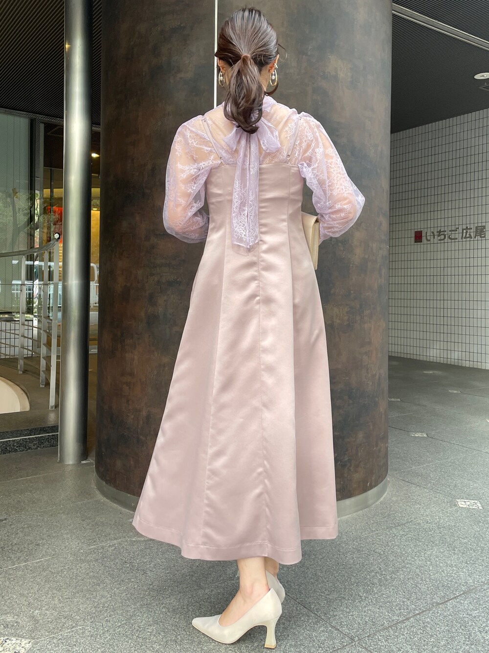 ベージュ系のパンプス、パープル系のドレス、ベージュ系のクラッチバッグを着用したレディースの冬コーディネートの8枚目の写真