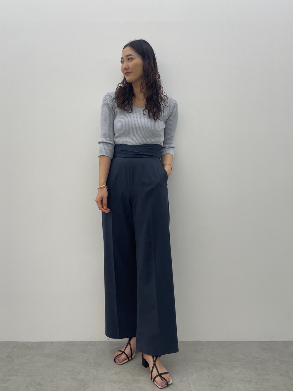 ブラック系のサンダル、ブルー系のスラックス、ブルー系のニット/セーターを着用したレディースの春コーディネートの3枚目の写真