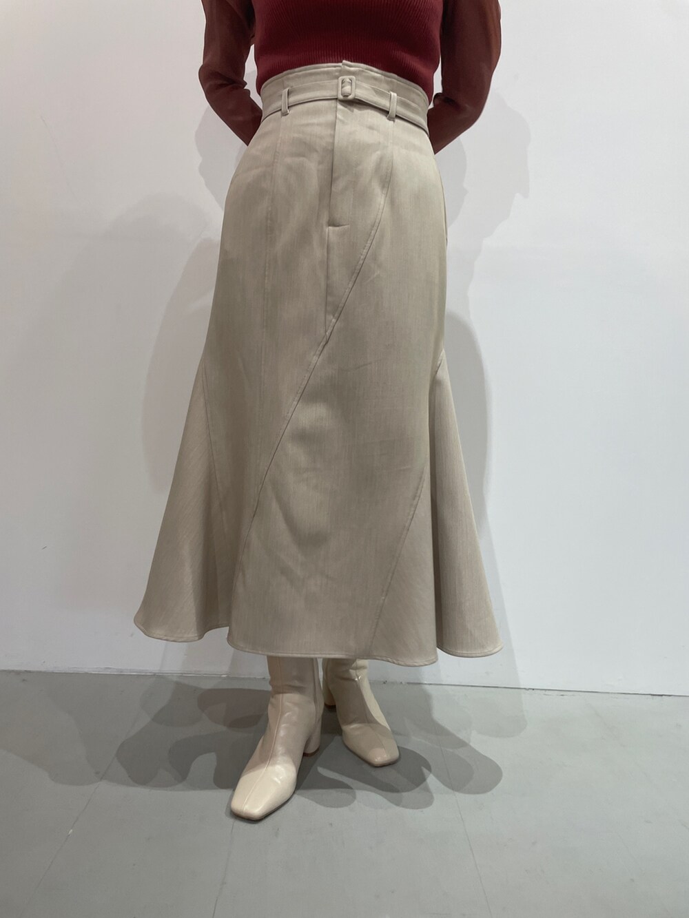 ホワイト系のブーツ、ベージュ系のスカート、ピンク系のニット/セーターを着用したレディースの夏コーディネートの8枚目の写真