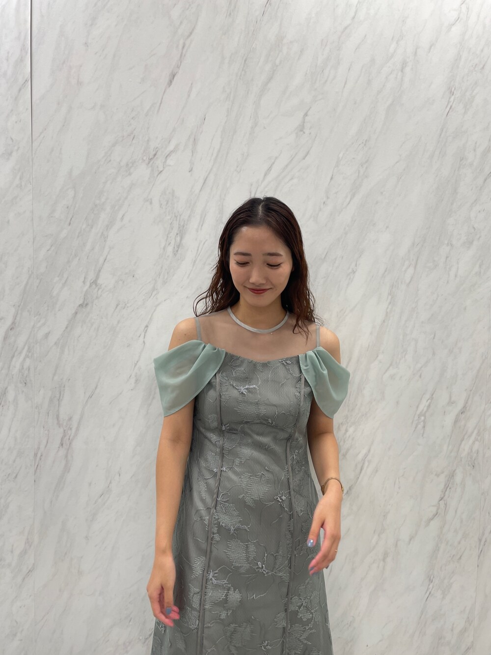 ホワイト系のパンプス、グリーン系のドレスを着用したレディースの冬コーディネートの5枚目の写真