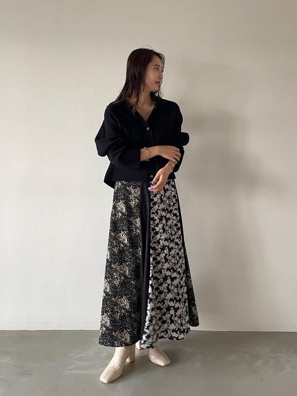 ブラック系のカーディガン/ボレロ、ホワイト系のブーツ、ブラック系のスカートを着用したレディースの夏コーディネートの3枚目の写真