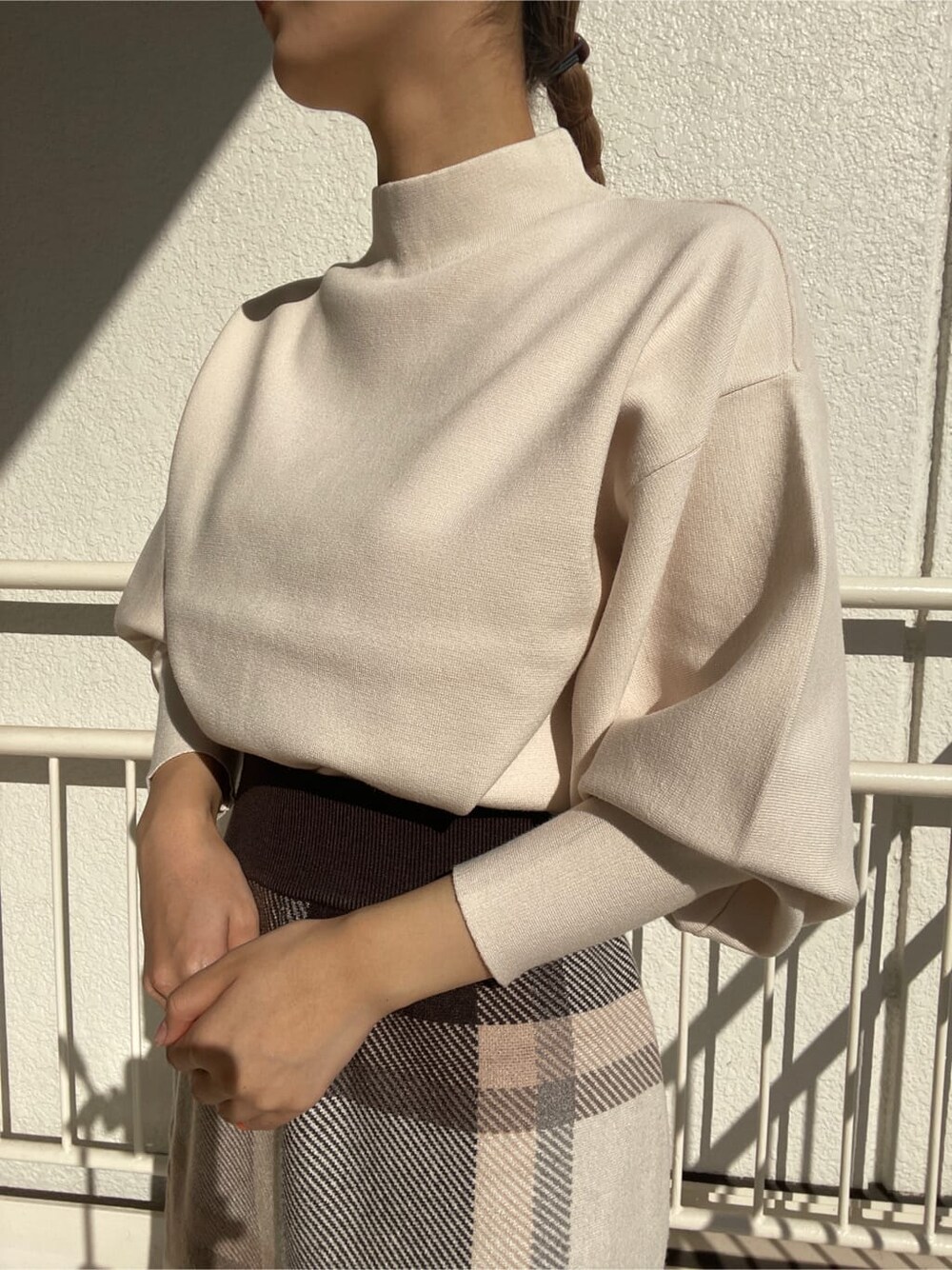 ベージュ系のその他シューズ、グレー系のスカート、ホワイト系のニット/セーターを着用したレディースの冬コーディネートの3枚目の写真