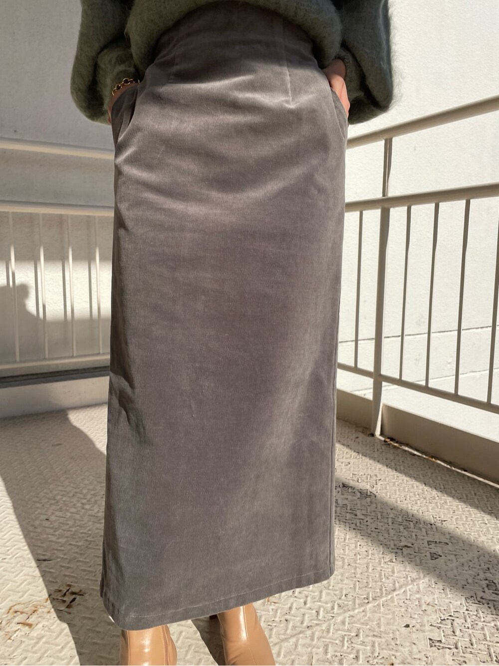 ベージュ系のその他シューズ、グリーン系のニット/セーター、グレー系のスカートを着用したレディースの秋コーディネートの7枚目の写真