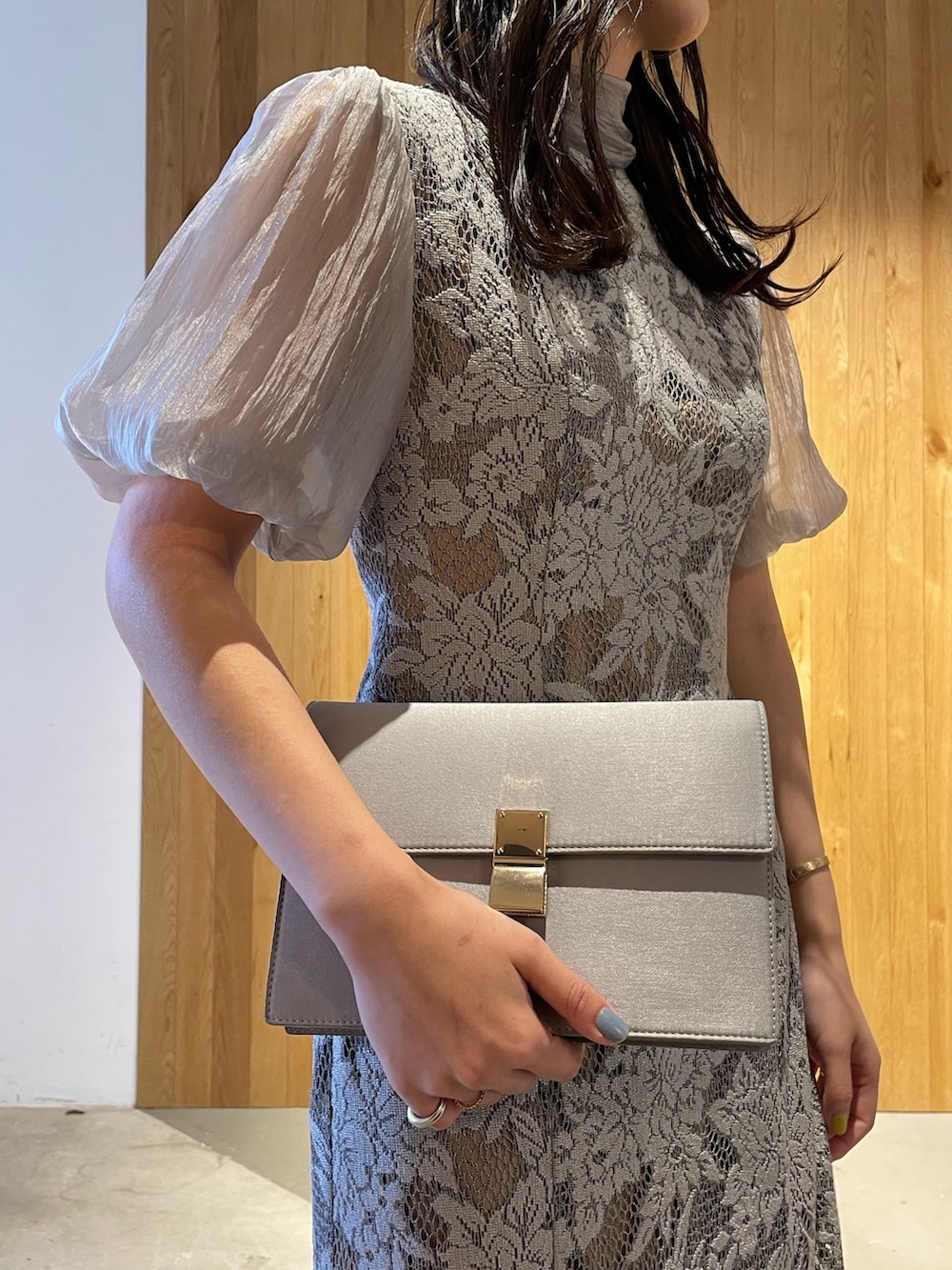 グレー系のパンプス、グレー系のクラッチバッグ、グレー系のドレスを着用したレディースの冬コーディネートの8枚目の写真
