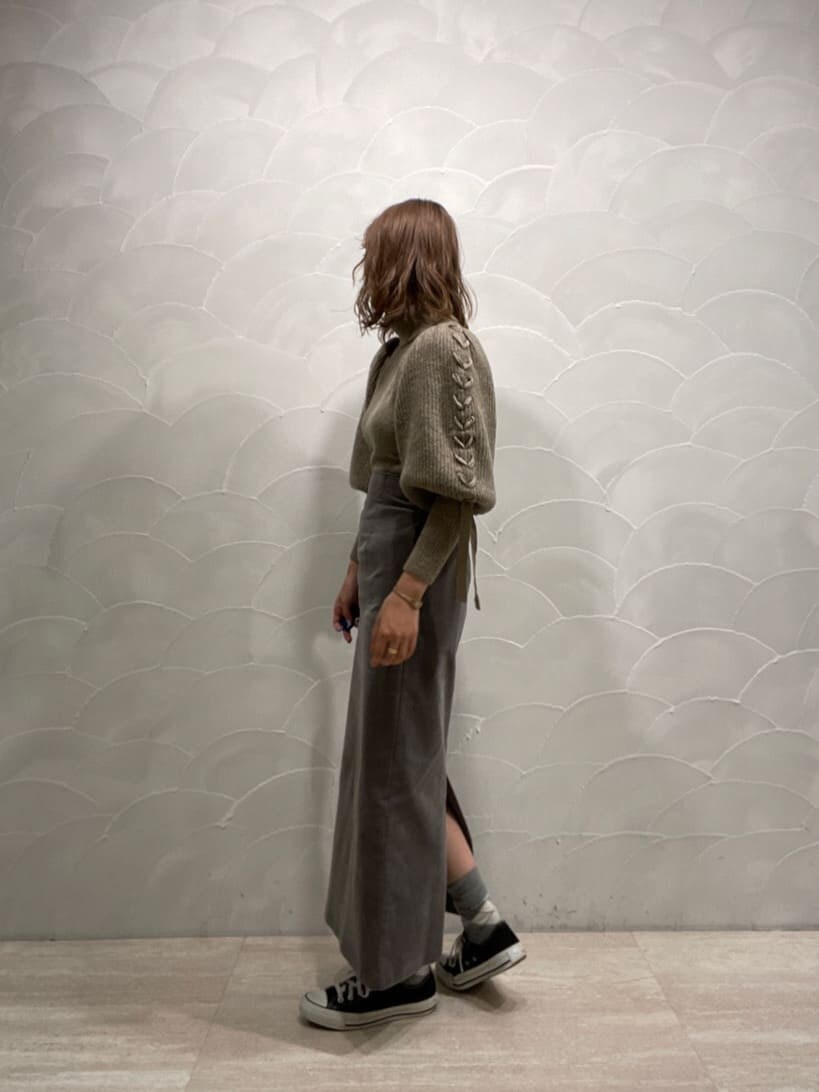 グレー系のスカート、ベージュ系のニット/セーターを着用したレディースの冬コーディネートの2枚目の写真