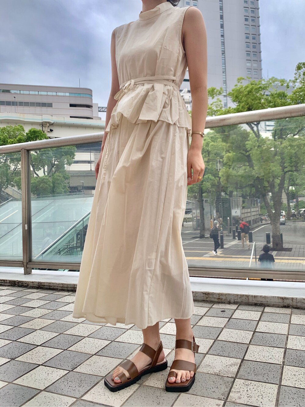 ブラウン系のサンダル、ホワイト系のワンピースを着用したレディースの夏コーディネートの2枚目の写真