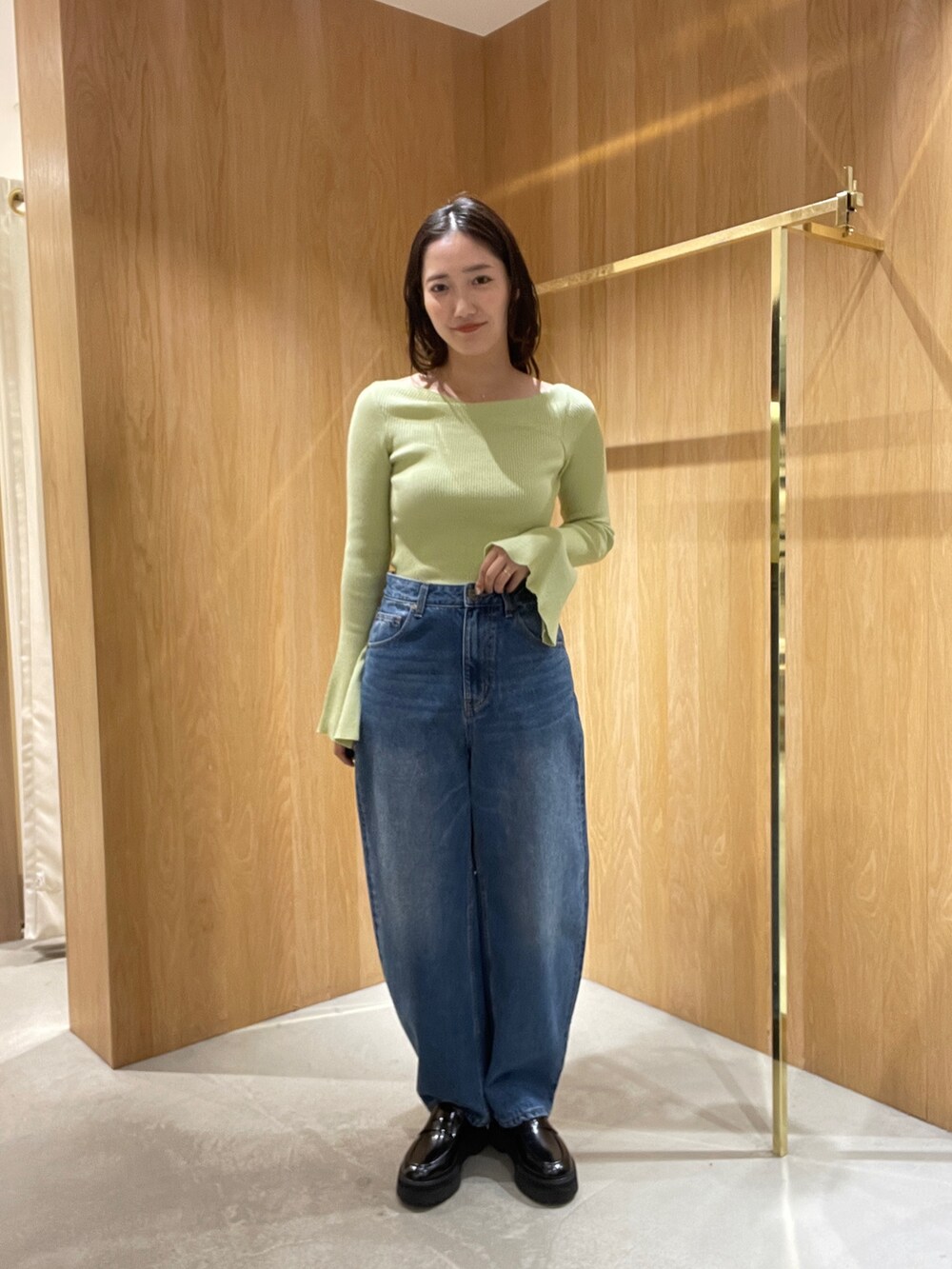 ブルー系のデニムパンツ、ホワイト系のブルゾン、グリーン系のニット/セーターを着用したレディースの秋コーディネートの4枚目の写真