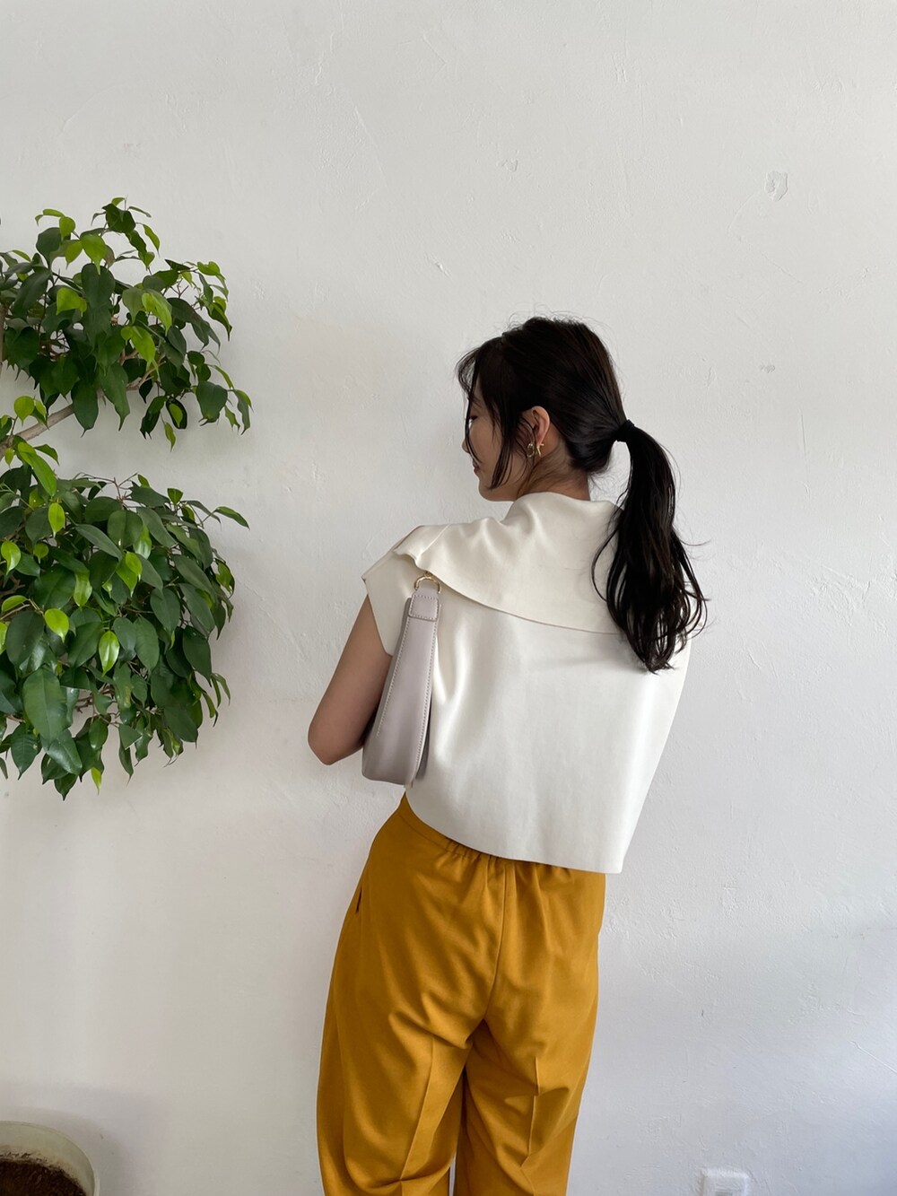 ベージュ系のサンダル、ホワイト系のニット/セーター、イエロー系のスラックスを着用したレディースの春コーディネートの5枚目の写真