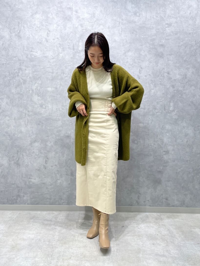ベージュ系のブーツ、ホワイト系のニット/セーター、ホワイト系のスカートを着用したレディースの秋コーディネートの3枚目の写真